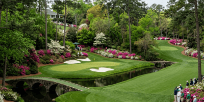 Golfer teeing off on a lush golf course surrounded by blooming azaleas and tall pine trees